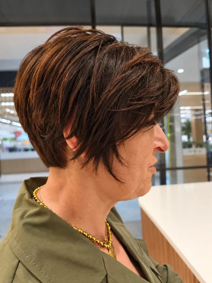Corte curto castanho acobreado com volume, visto de perfil