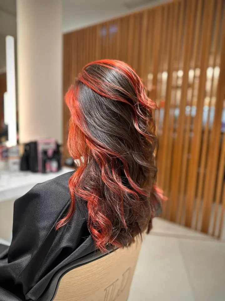 Cabelo escuro com madeixas vermelhas intensas